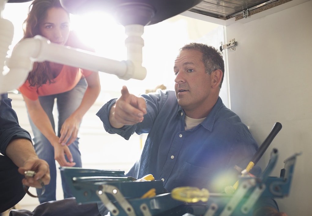 Plumbers working on removing a bathroom vanity