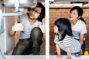 family fixing pipe under sink