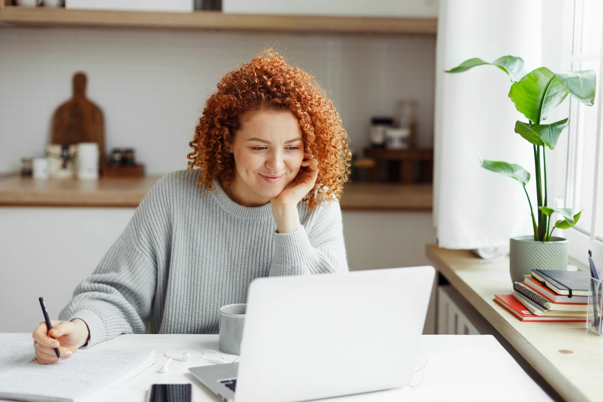 young woman researching home insurance for plumbing on computer
