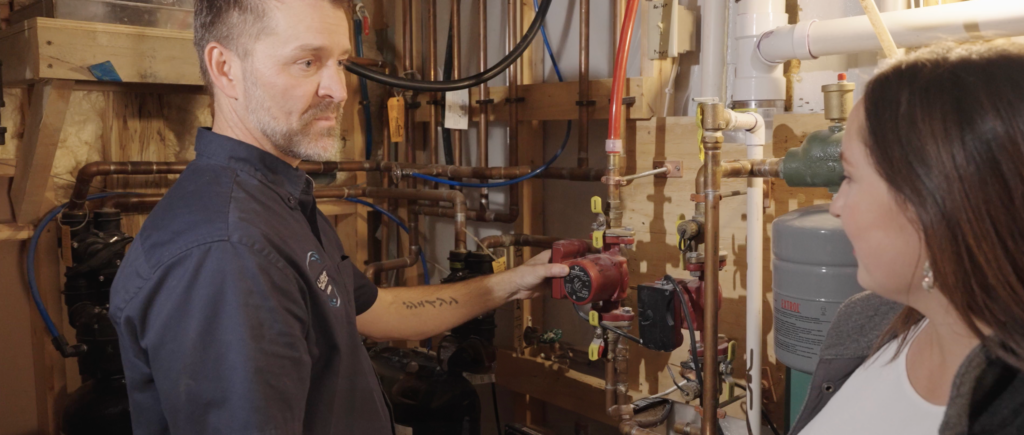 An A.J. Alberts Plumbing technician walks a homeowner through their plumbing service.