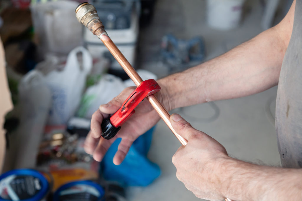 plumber holding copper pipe