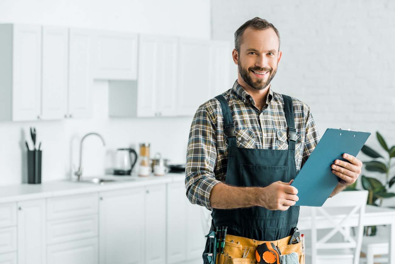 friendly plumber smiling in kitchen