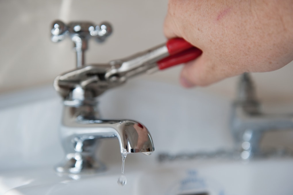 man fixing a defective faucet causing low water pressure