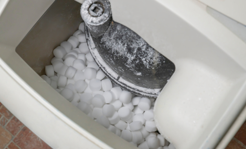 Close-up image of salt pellets in a water softener.
