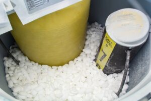 Close-up of a water softener filled with salt.