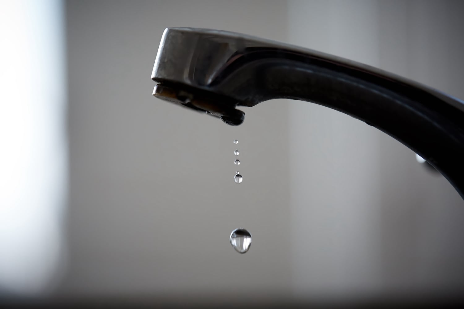 slow hot water close up of leaky sink faucet