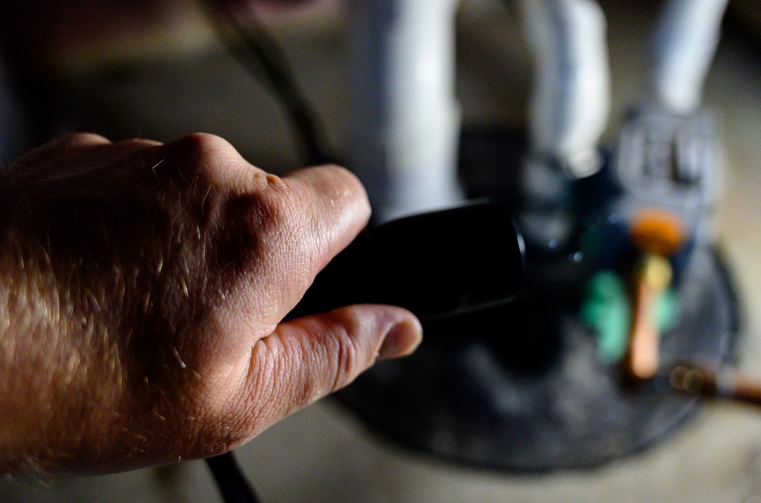 sump pump maintenance closeup of hand making home repairs on sump pump