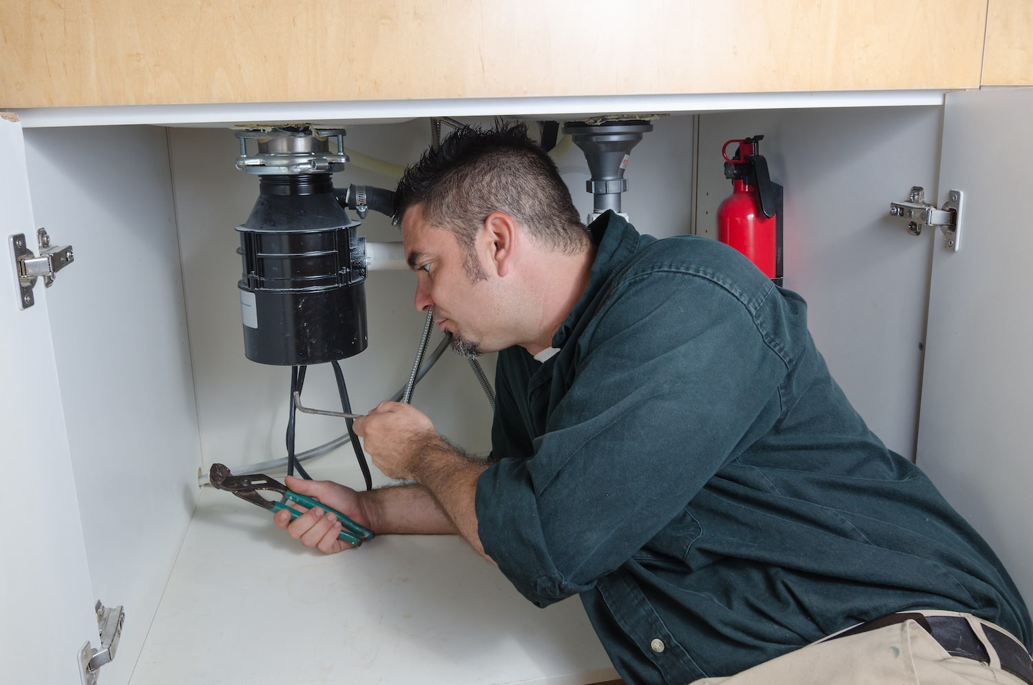 how to unclog a garbage dispoal- plumber fixing sink garbage disposal