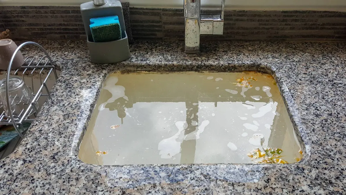 clogged sink filled with dirty water