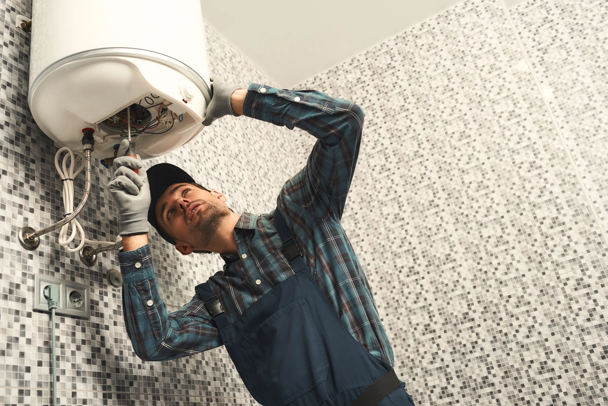 man installing water heater in batroom